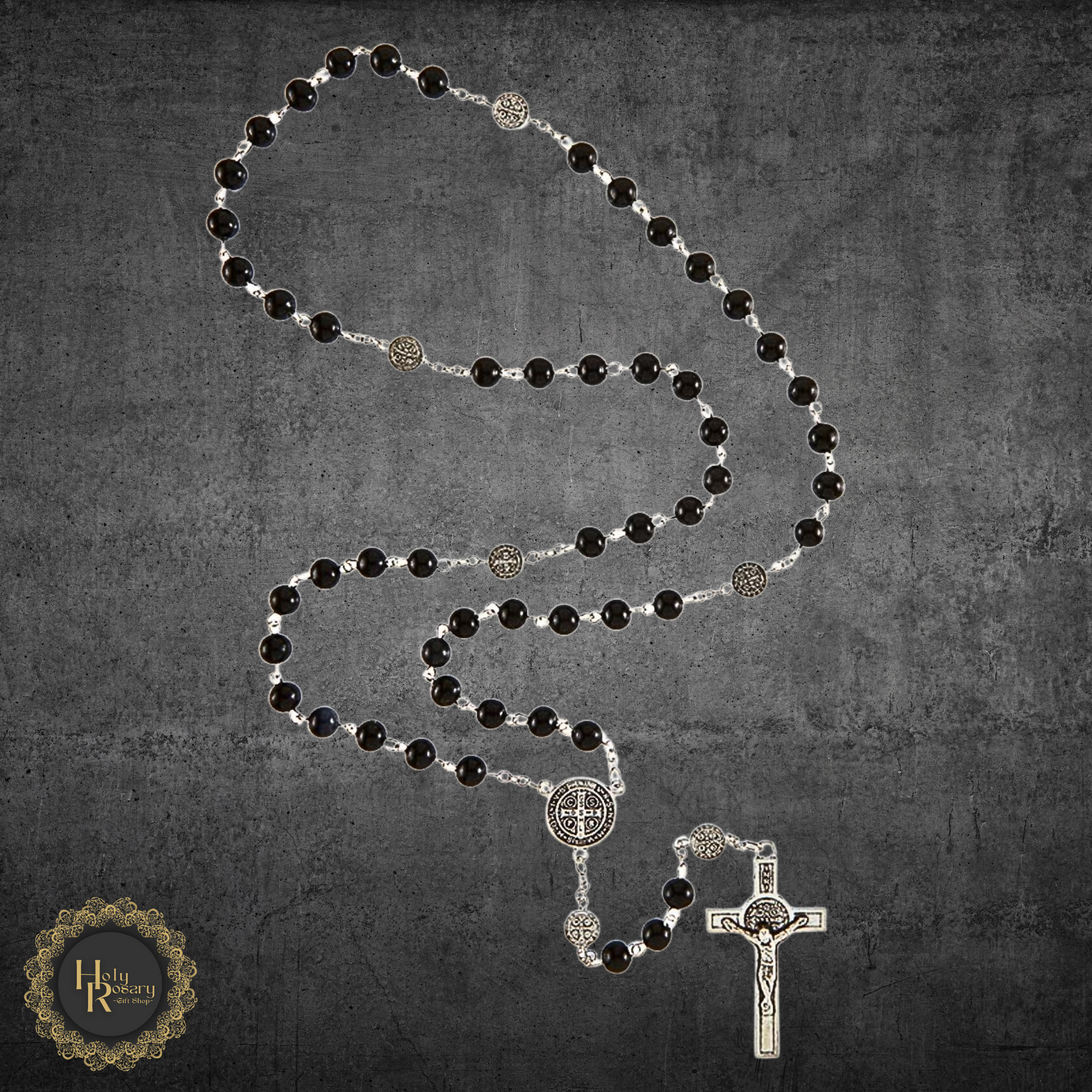 Black rosary beads with St. Benedict medals displayed for religious devotion